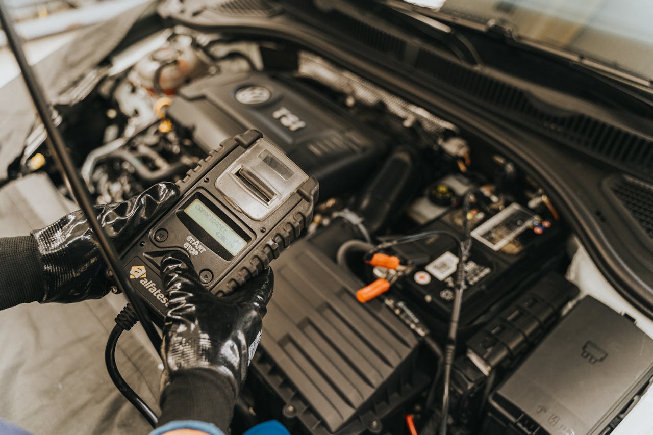 Services Mechanic diagnosing a car engine with a diagnostic tool, showcasing technical expertise and automotive care.